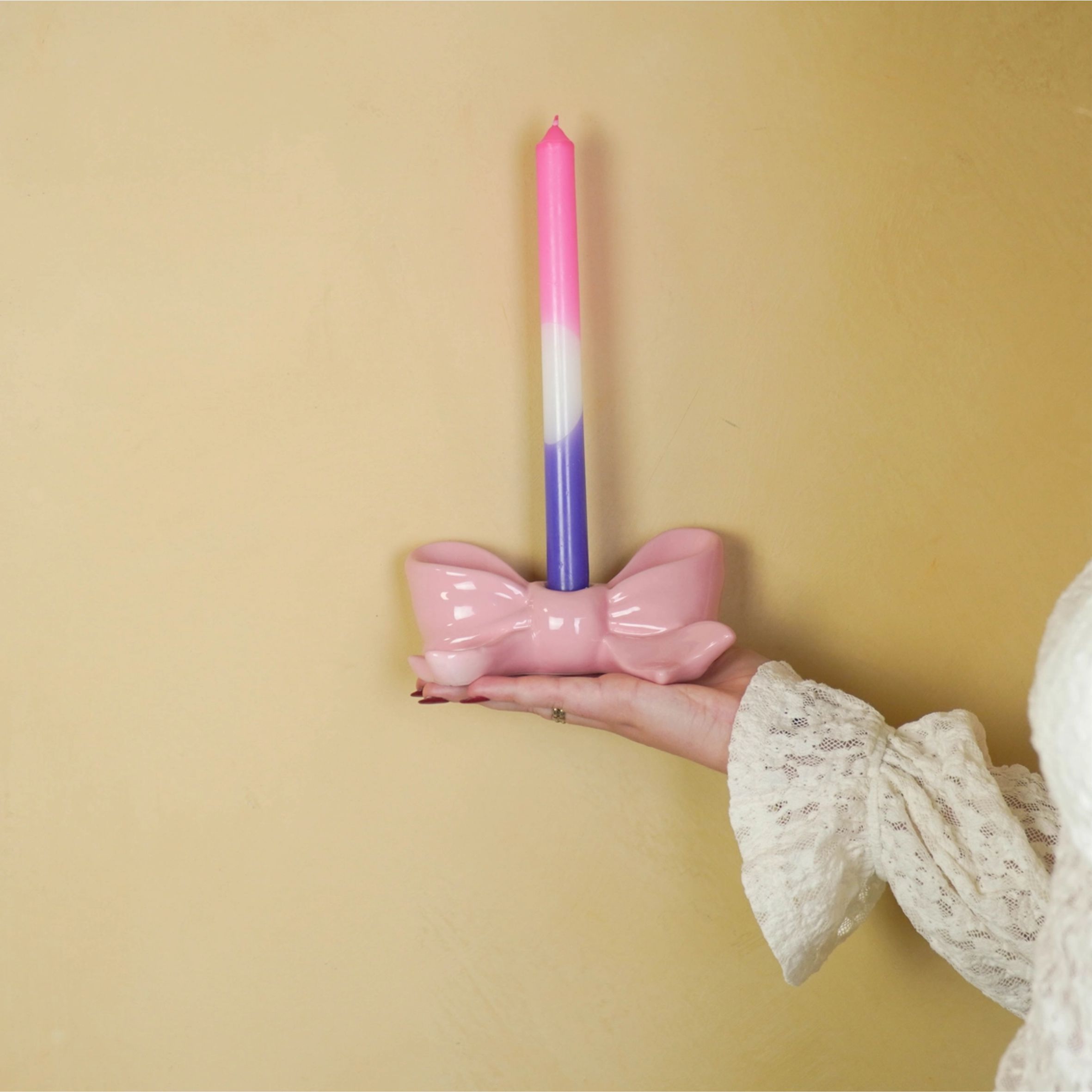 Ihastuttava vaaleanpunainen rusetin mallinen kynttilänjalka kruunukynttilälle