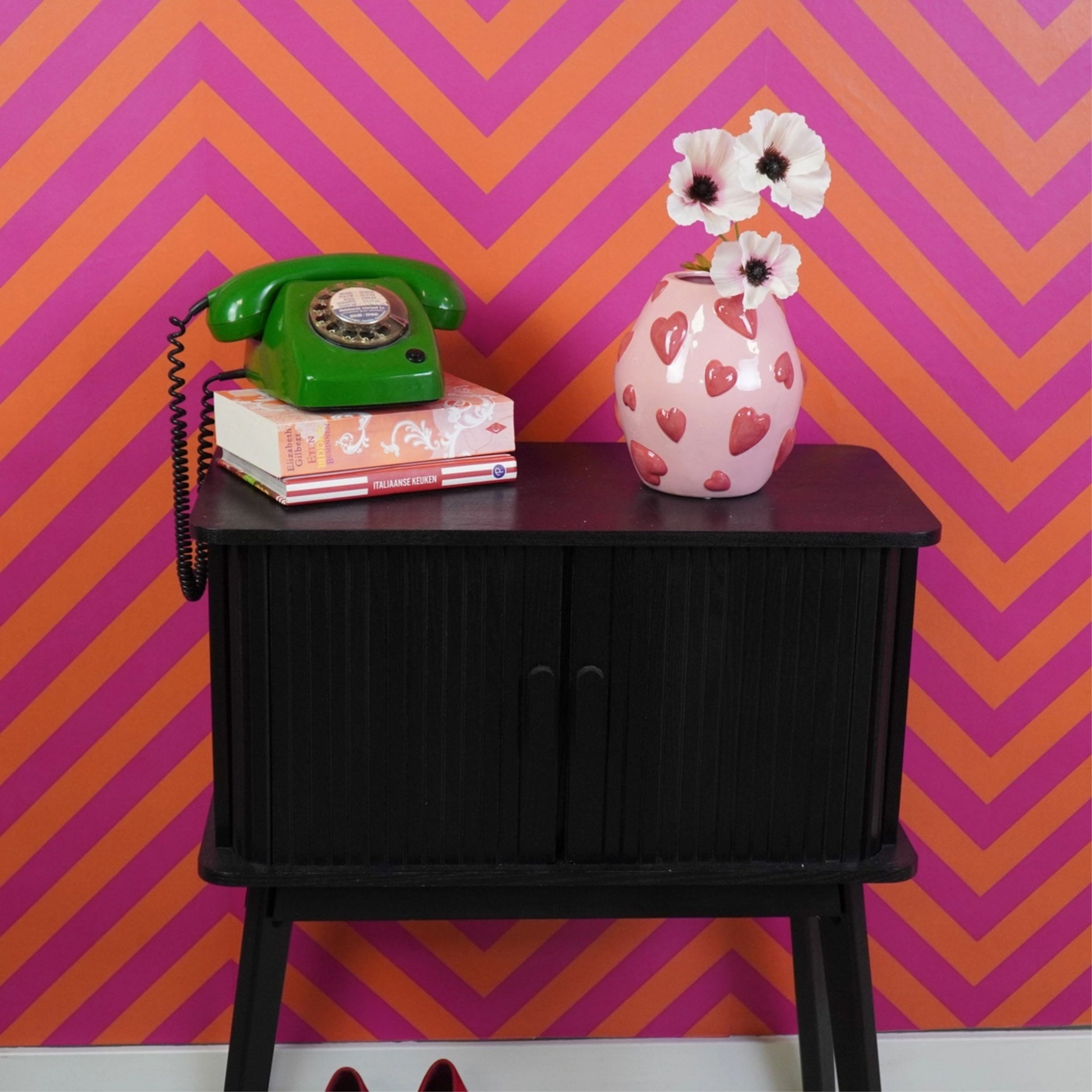 Vaaleanpunaisella pohjalla punaisia sydämiä koholla, sydänkuvioitu kaunis maljakko