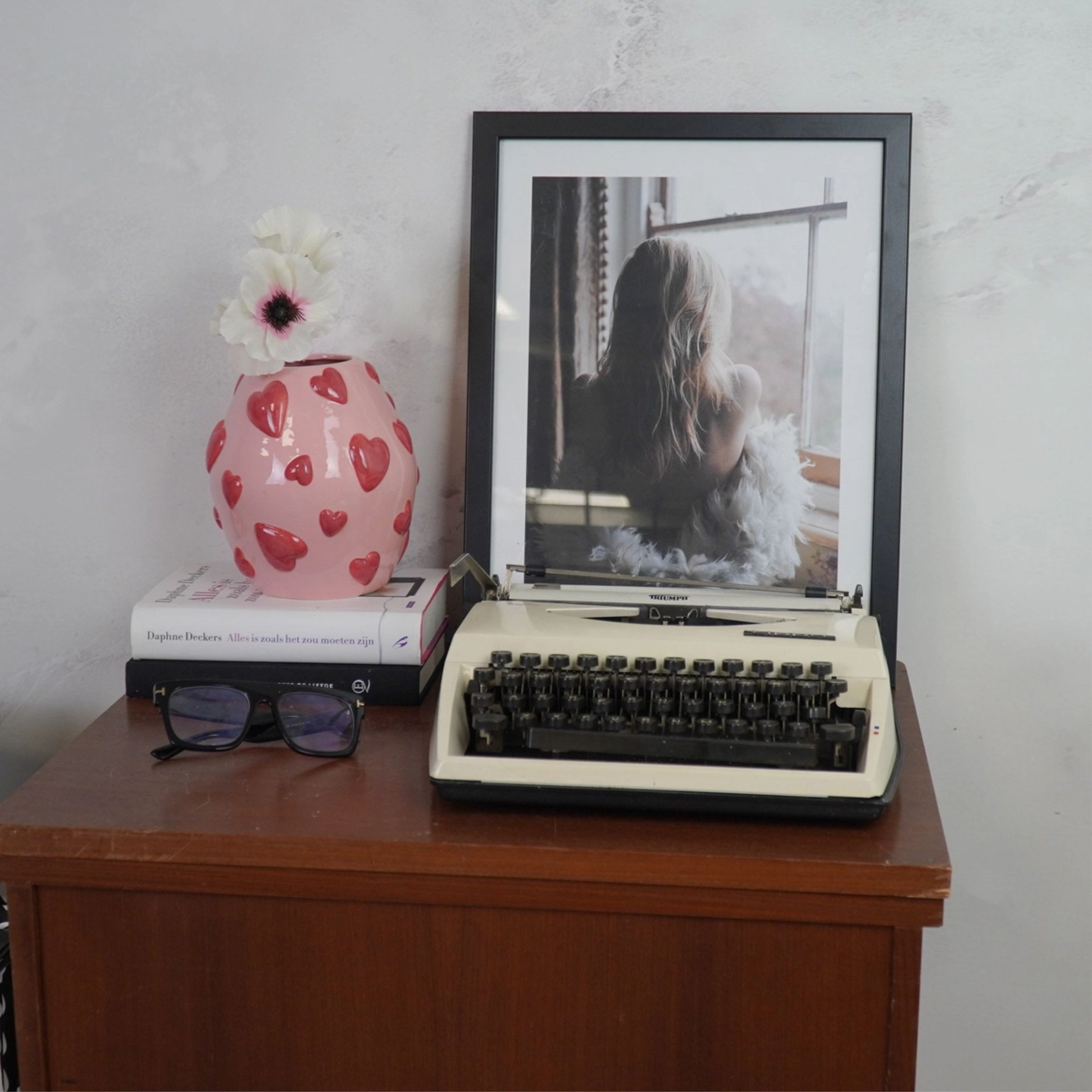 Vaaleanpunaisella pohjalla punaisia sydämiä koholla, sydänkuvioitu kaunis maljakko